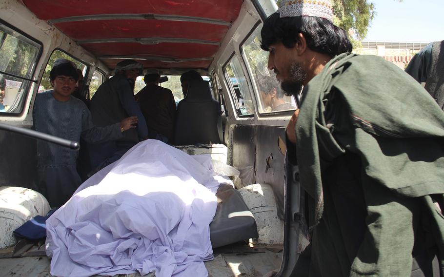 Afghans transport the body of a woman who was killed during a raid conducted by Afghan special forces, in the southern Helmand province, Monday, Sept. 23, 2019. 