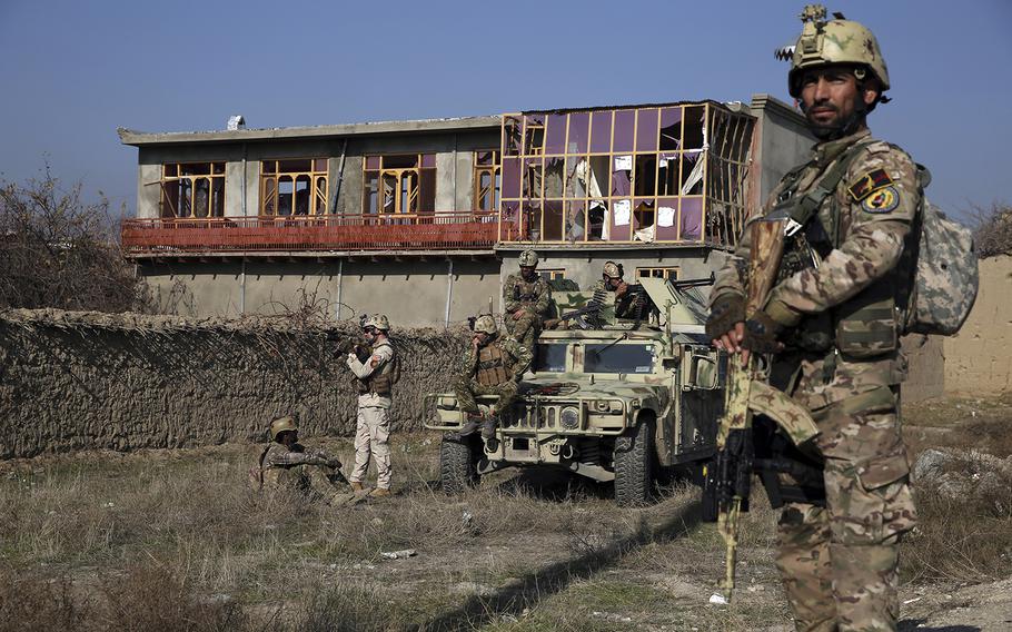 Security personnel stand guard near the site of an attack near the Bagram Airfield in Parwan province of Kabul, Afghanistan, Wednesday, Dec. 11, 2019. 