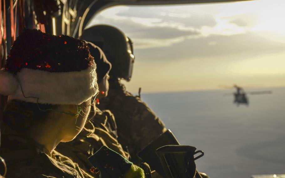 Troops on a holiday tour to bring cheer to U.S. service members forward deployed throughout eastern Syria watch the sunset from the back of a CH-47 Chinook helicopter in the skies over the wartorn country on Monday, Dec. 23, 2019.

