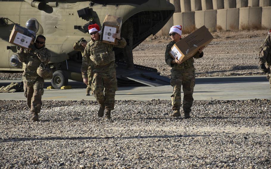 Brig. Gen. Stephen Jost, chief of staff for the U.S.-led coalition to defeat the Islamic State group in Iraq and Syria, is pictured here (center) carrying a box of treats from a CH-47 Chinook in Syria's Deir el-Zour province during a holiday mission to spread cheer to forward deployed troops at an austere camp on Monday, Dec. 23, 2019.


