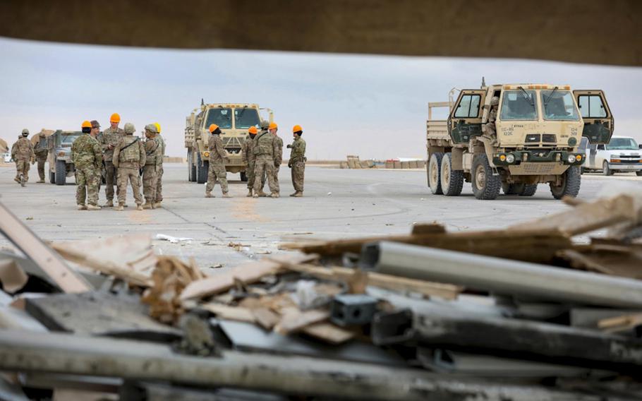 Soldiers, airmen and civilian contractors remove debris from recent missile attacks at al Asad Air Base, Iraq, Jan. 12, 2020. 