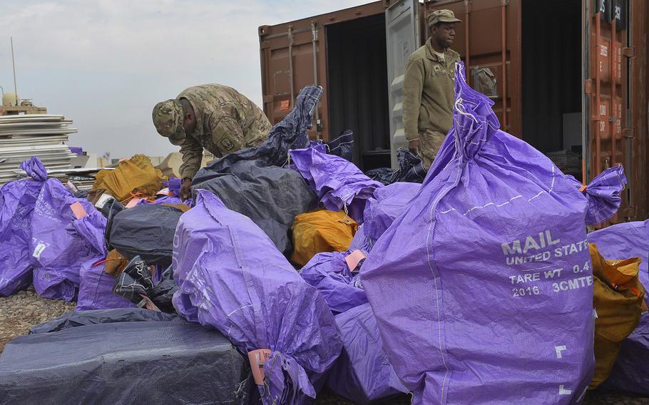 Sgt. Alvin Bethea Jr. walks past a pile of mailbags being sorted on Qayara Airfield West, March 17, 2017.