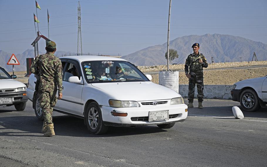 Two Afghan soldiers stand watch over a key road out of Kabul, Afghanistan, on Saturday, Feb. 22, 2020, during the first day of an agreed reduction of violence between the Taliban and the U.S. forces. Government forces are also to stand down, and are only allowed to fight if attacked, said Gawhar Khan Baburi, the district governor of Surobi.
