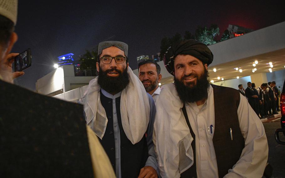 High-ranking Taliban official Anas Haqqani, left, and a press aide for the group meet with reporters on the eve of a historic agreement between the militant group and the United States in Doha, Qatar, Feb. 28, 2020.