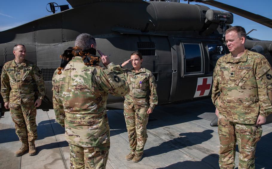 First Lt. Abigail Holstein salutes Col. Greg Fix, brigade commander for the 34th Expeditionary Combat Aviation Brigade, after being presented with the Purple Heart medal for her injuries sustained during the theater ballistic missile attacks at Al Asad Air Base, Iraq, on January 8, 2020. To the left and right of her stands Command Sgt. Maj. Todd Sudheimer and Lt. Col. Kyle Liudahl, her battalion command team with 2-147th Assault Helicopter Battalion.