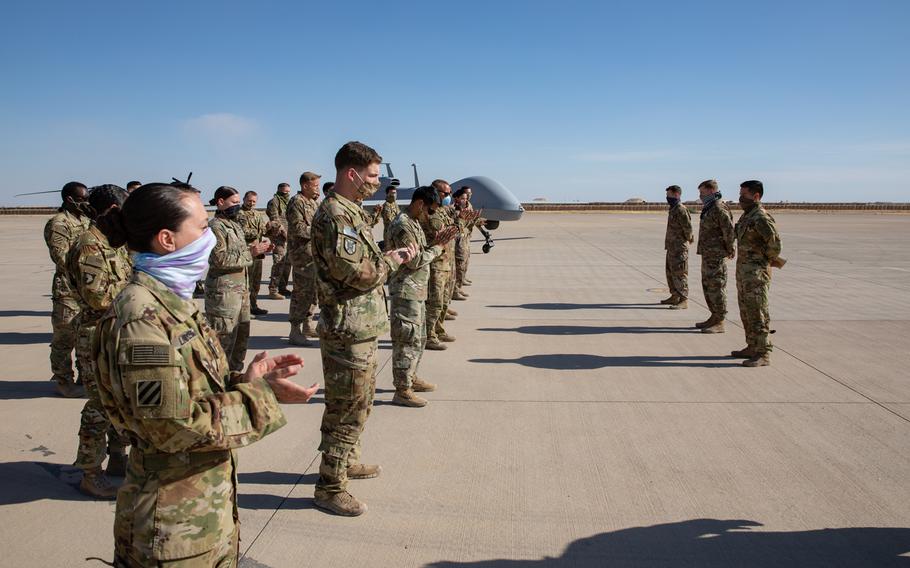 Members of Delta Company, 82nd Aviation Regiment stand in formation on May 3, 2020, (wearing masks and maintaining physical distancing standards for COVID-19 prevention) to recognize their fellow service members as they were presented the Purple Heart medal for their injuries sustained during the theater ballistic missile attacks at Al Asad Air Base, Iraq, on January 8, 2020. 