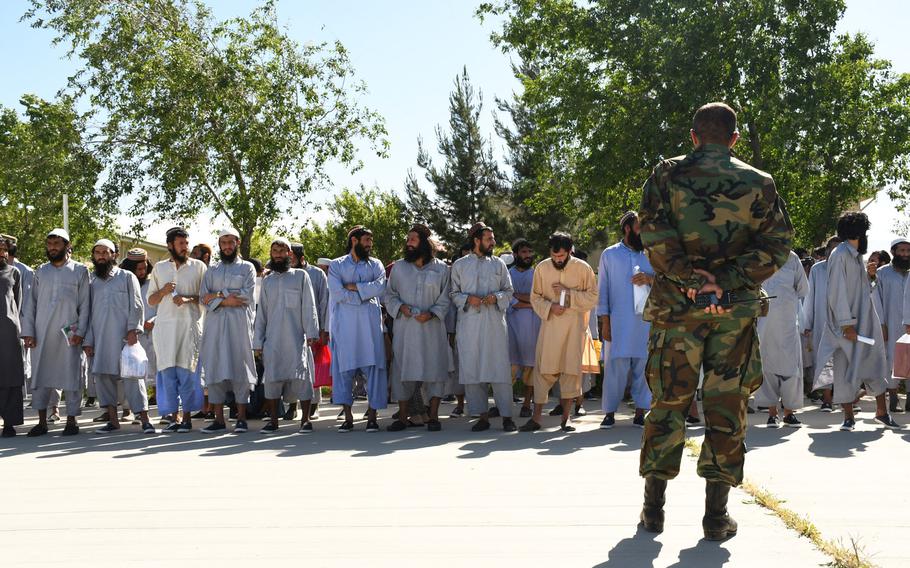 An Afghan soldier keeps an eye on Taliban prisoners before their release from Bagram prison on Tuesday, May 26, 2020. 