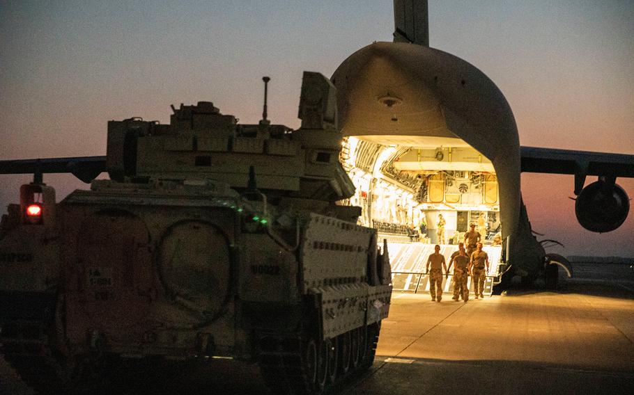 U.S. Army soldiers and airmen unload Bradley fighting vehicles from a C-17 aircraft near northeastern Syria Sept. 18, 2020. 
