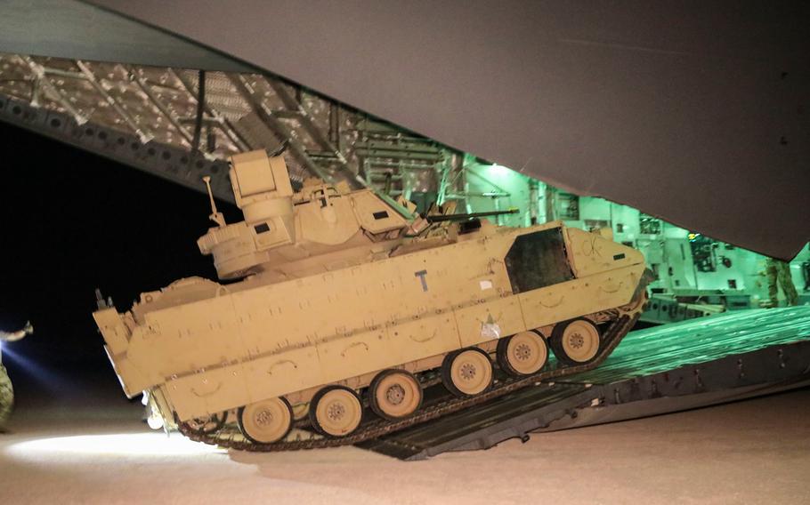 U.S. Army soldiers and sirmen unload Bradley fighting vehicles from a C-17 aircraft near northeastern Syria Sep 18, 2020. 