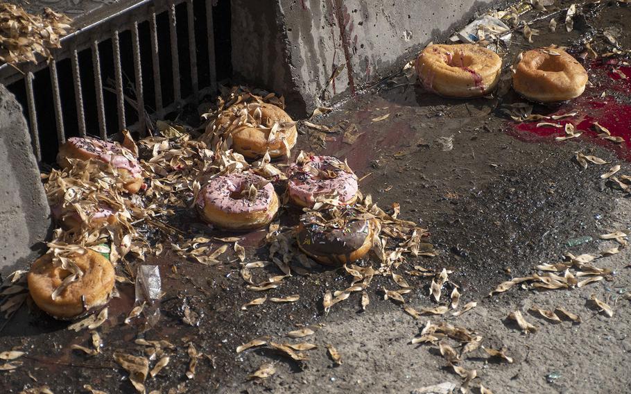 Donuts litter the street in Kabul's Shar-e-Now neighborhood on Saturday, Nov. 21, 2020, after a rocket attack damaged several shops in the area and destroyed a bakery van. 