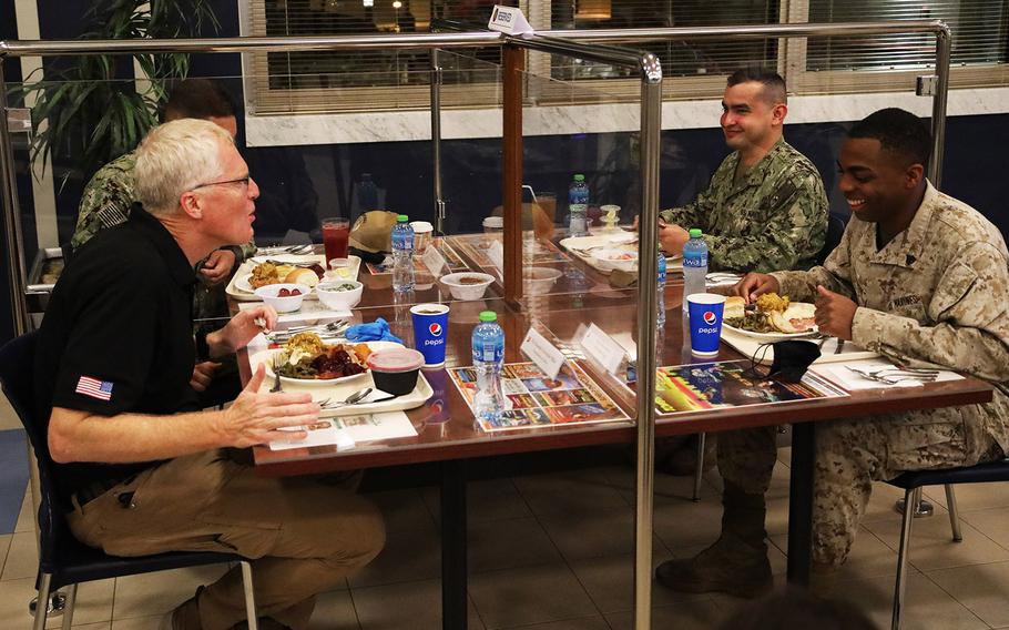 Acting Defense Secretary Christopher Miller, left, speaks with Marine Sgt. Joshua Jackson, right, with Fleet Logistics Center at Naval Support Activity Bahrain over a Thanksgiving meal Nov. 25, 2020. Miller is visiting troops in the Middle East for the Thanksgiving holiday.