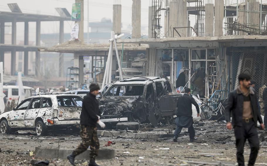 Afghan security personnel inspect the site of a bombing attack in Kabul, Afghanistan, Sunday, Dec. 20, 2020.  
