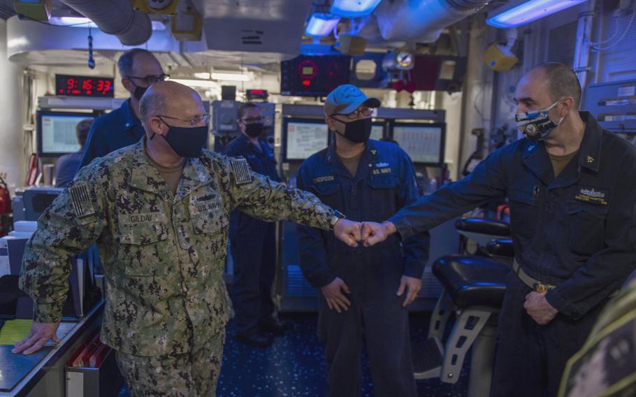Adm. Mike Gilday, chief of naval operations, left, greets Chief Petty Officer Tyronn Hampton aboard the destroyer USS John Paul Jones in the Persian Gulf, Jan. 13, 2021.  

