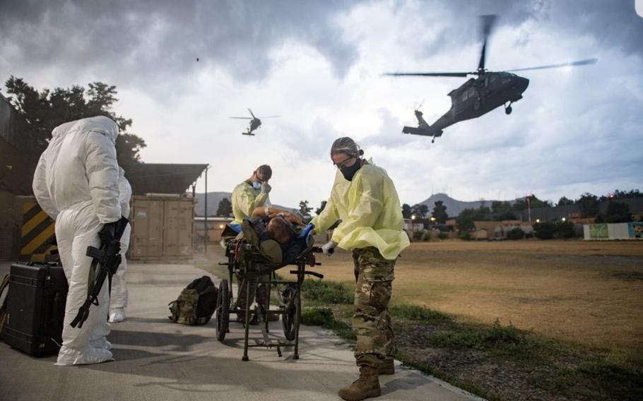 Troops at NATO Resolute Support Headquarters in Kabul, Afghanistan, assist a patient during an aeromedical evacuation due to COVID-19, in a photo taken in 2020. 
