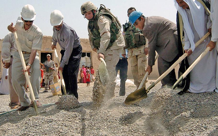 Capt. Whitney Campbell, center, commander of Battery C, Task Force 2-11 Field Artillery, participates in a ceremony in 2004 for the Kharabrud elementary school, which was funded through the Commander's Emergency Response Program. Lawmakers have directed the military to end multibillion-dollar program used in Afghanistan and Iraq. 

