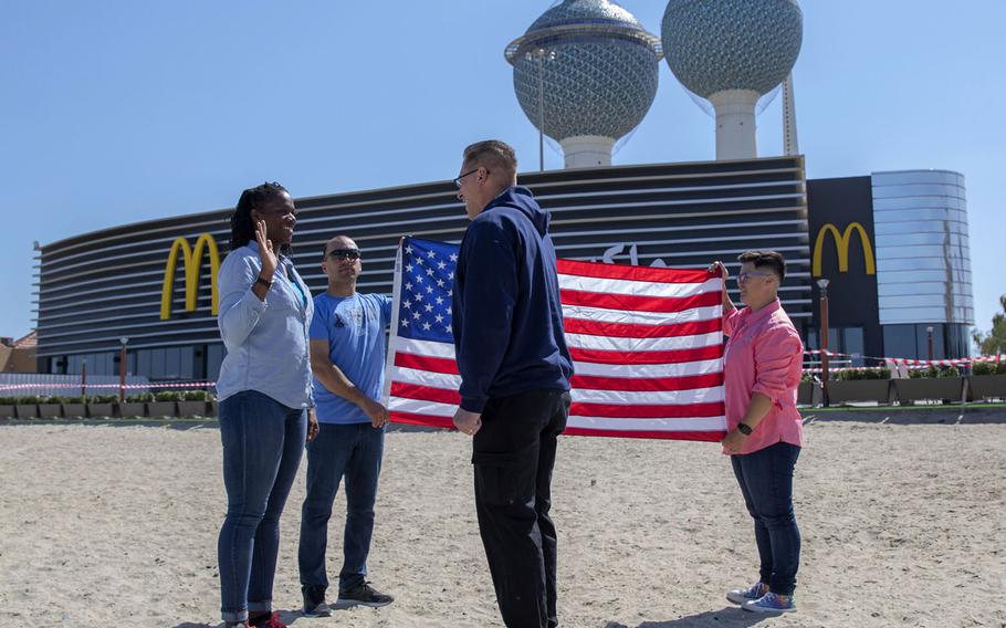 U.S. Army Staff Sgt. Nicole Atchley, with the 413th Combat Sustainment Support Battalion, affirms her reenlistment oath, led by Col. Christian Pajak, 413th CSSB commander, Feb. 26, 2021, in Kuwait City, Kuwait. Atchley chose to reenlist in front of a McDonald's because she makes a point of eating at one in every country she visits, the Army said.
