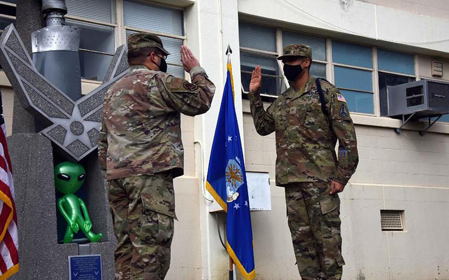 Staff Sgt. James Taylor enlists into the Space Force at the Presidio of Monterey, Calif., as ''Buddy, the alien mascot,'' looks on in a photo shared by the Defense Language Institute Foreign Language Center Thursday, Feb. 11, 2021. The photo was later deleted. 

