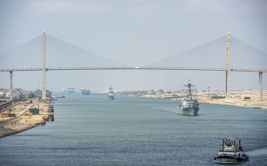 The cruiser USS Monterey, left, and the destroyer USS Thomas Hudner sail behind the aircraft carrier USS Dwight D. Eisenhower during a Suez Canal transit, April 2, 2021.  
