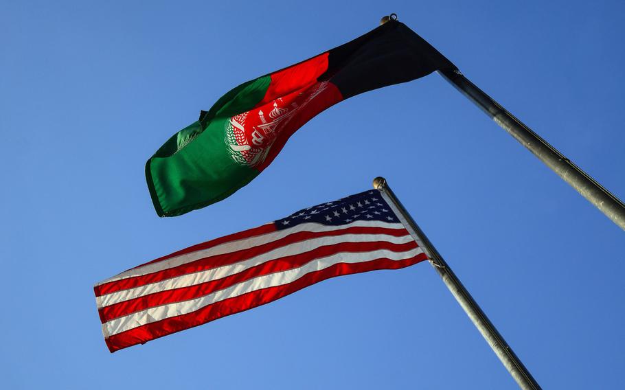 The American and Afghan flags fly over a base in Kabul, Afghanistan in 2019. Saed Ismail Amiri, who attempted to cheat Afghanistan's government out of more than $100 million, has pleaded guilty to fraud in a federal court in Los Angeles, the Justice Department said April 28, 2021.  

