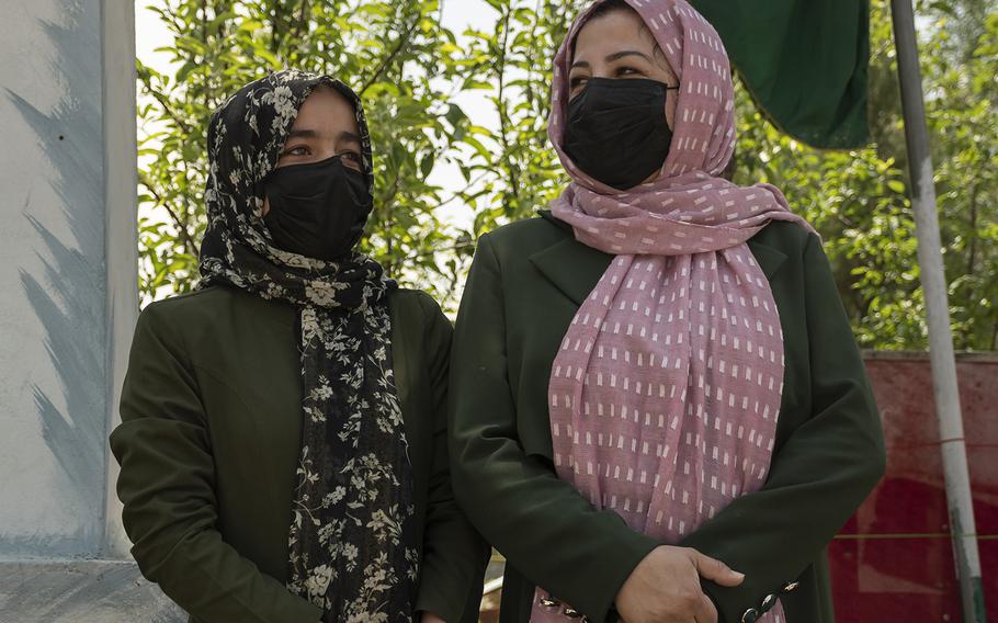 Sadiqa Halim, left, and Fatima Ravi watch students leaving a school in central Kabul on Sunday, May 2, 2021. Both women, who work at a school, said they were unhappy with the U.S. decision to withdraw from the country. 