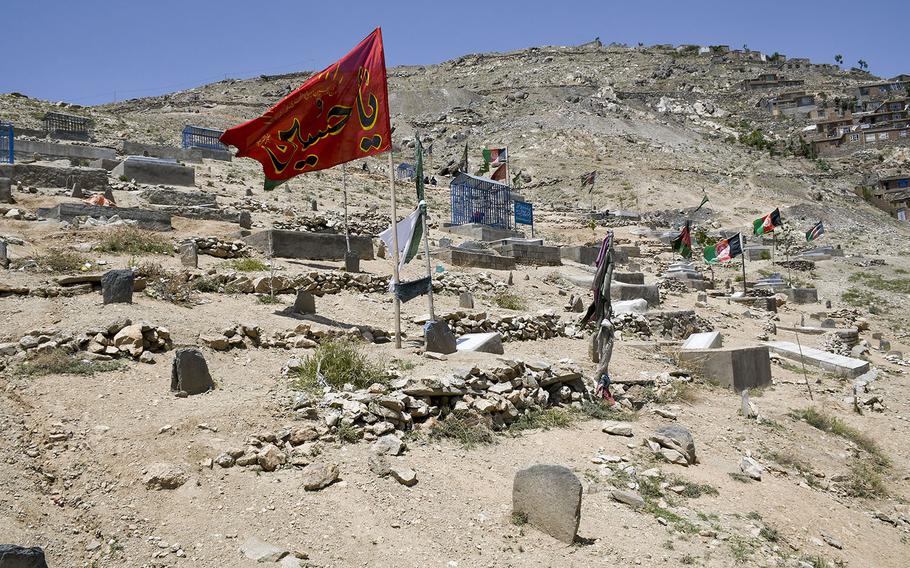 Flags fly over a cemetery in the Dasht-e-Barchi neighborhood, a majority Shiite district in the west part of Kabul, Afghanistan, where numerous funerals took place after an attack Saturday, May 8, 2021 on a school there.