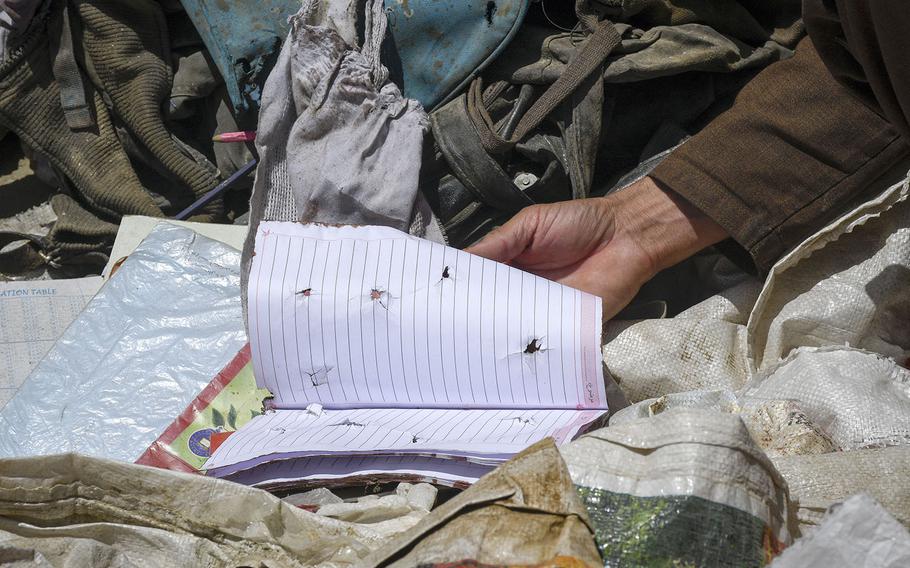 Locals examine items left behind after a deadly attack on the Syed Al-Shahda school in west Kabul, Afghanistan. 