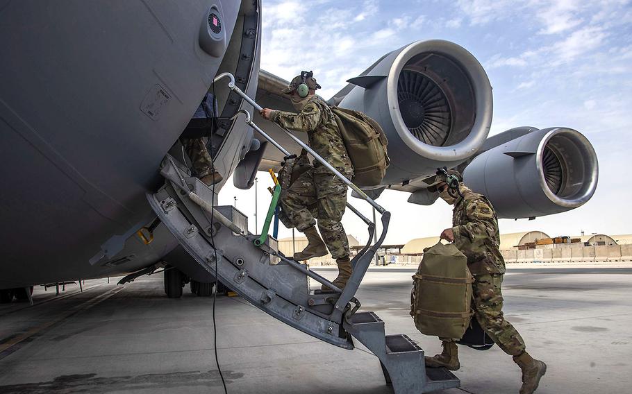 Aircrew assigned to Al Udeid Air Base, Qatar, carry their gear April 27, 2021, into a C-17 Globemaster III assigned to Joint Base Charleston, South Carolina. Air Force C-17s and other mobility aircraft are assisting with the safe and orderly U.S. drawdown operations from Afghanistan.