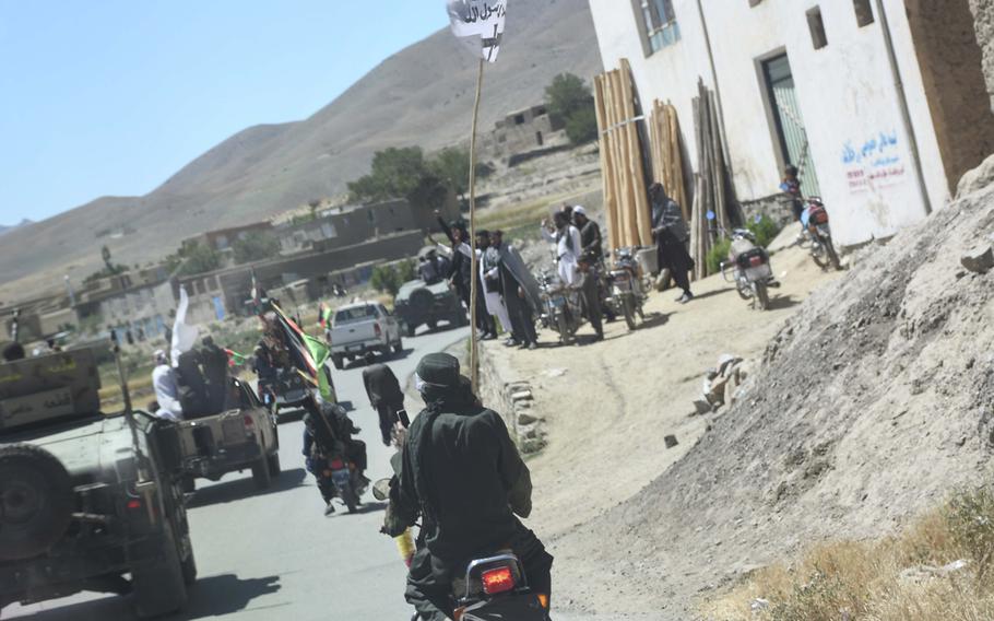 A man flying a Taliban flag weaves between soldiers of the Afghan National Army’s 203rd Corps as they venture to a Taliban stronghold in Logar province, a mission only made possible by unprecedented mutual cease-fires between the Taliban and the Afghan government over the weekend.