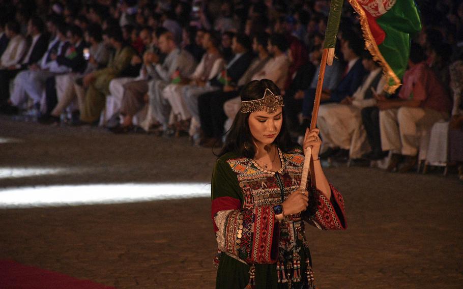 An Afghan woman carries her nation’s flag at the restored Darul Aman Palace during a celebration of Afghanistan’s Independence Day in Kabul on Aug. 18, 2020. 

