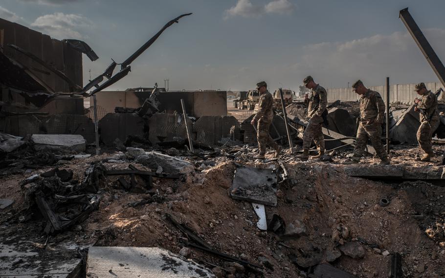 U.S. officials stand near a crater caused by Iranian airstrikes inside al Asad Air Base near Anbar, Iraq, on Jan. 13, 2020. 