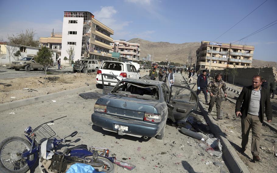 In this Wednesday, Nov. 13, 2019, file photo, Afghan security personnel gather at the site of a car bomb attack in Kabul, Afghanistan. 