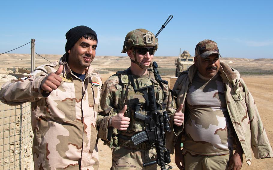 Iraqi and U.S. soldiers pose along the perimeter of Al Asad Airbase in Anbar province, Feb. 14, 2020. The U.S.-led coalition in Iraq is suspending training and moving some personnel to the United Kingdom due to the coronavirus outbreak.