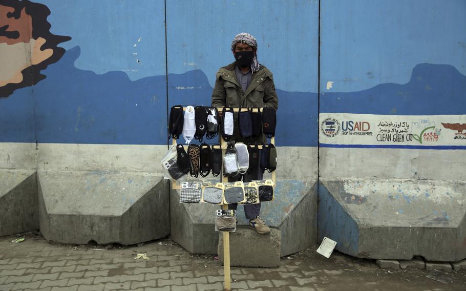 A street vendor selling protective masks aimed at preventing the spread of the new coronavirus waits for customers in Kabul, Afghanistan, on March 23, 2020.