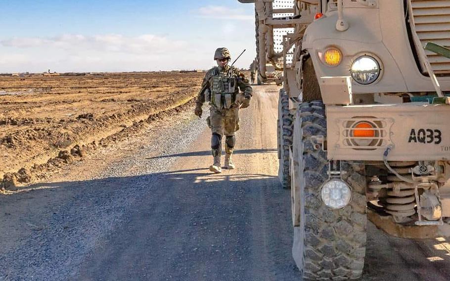 A Romanian soldier walks next to his armored vehicle in Afghanistan, in an undated photo. On Wednesday, two Romanian soldiers were injured by a bomb blast in Kandahar province.

