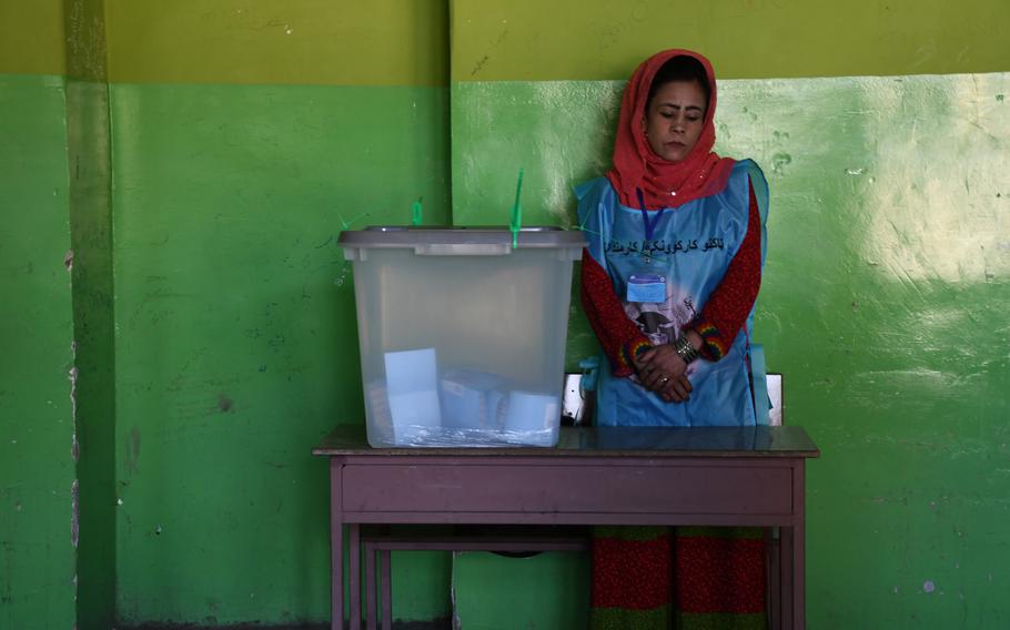 An election worker in Kabul waits for voters to cast their ballots in Afghanistan's presidential election on Saturday, Sept. 28, 2019.