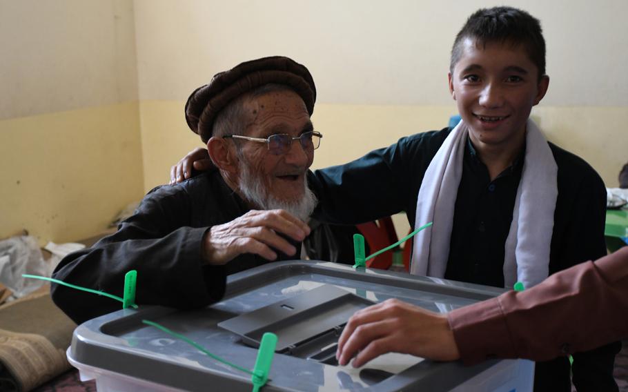 Ghulam Hazrat, 80, votes in Afghanistan's presidential election on Saturday, Sept. 28, 2019, with the help of his son.