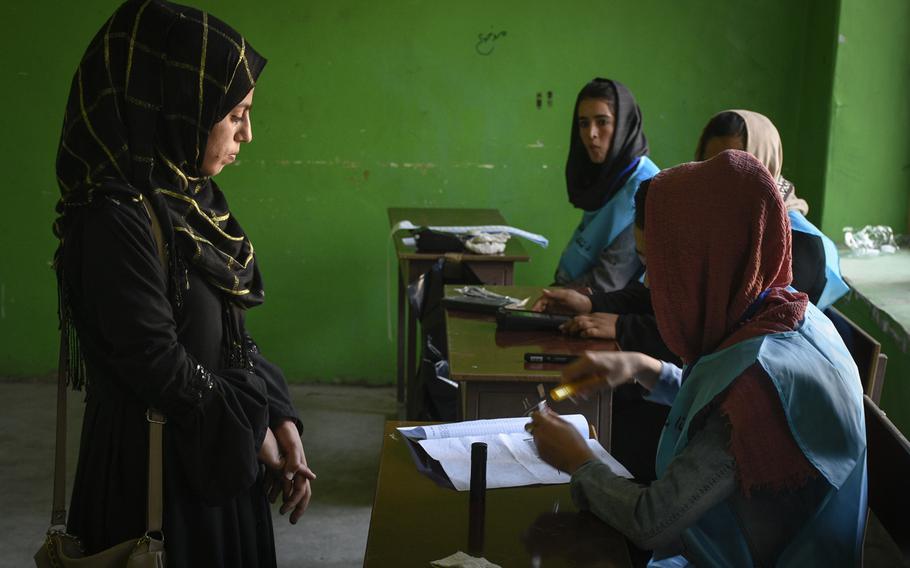 Hasiba, 19, prepares to vote in her first presidential election at a polling station in downtown Kabul, Afghanistan, on Saturday, Sept. 28, 2019.