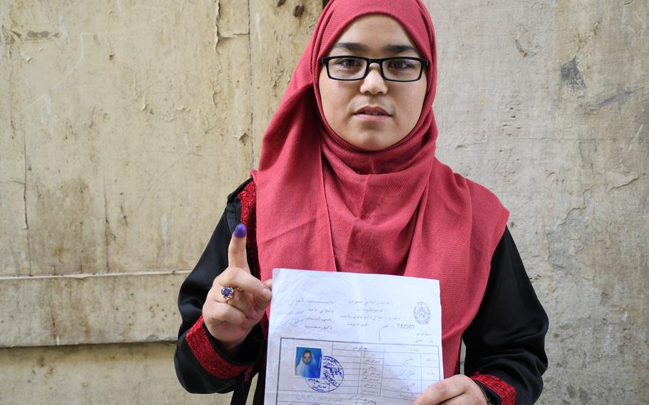 Banin Razayee, 19, shows an ink-covered finger, indicating she voted in Afghanistan's presidential election on Saturday, Sept. 28, 2019.