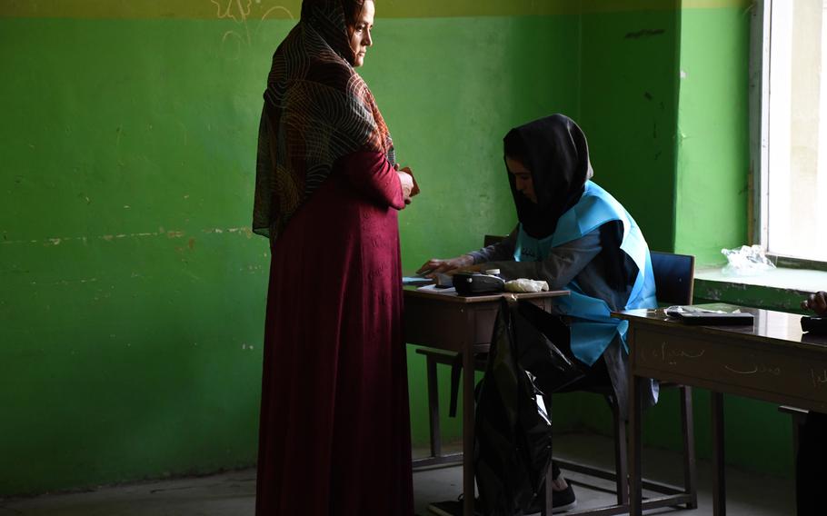  A woman is identified before voting in Afghanistan's presidential election on Saturday, Sept. 28, 2019.