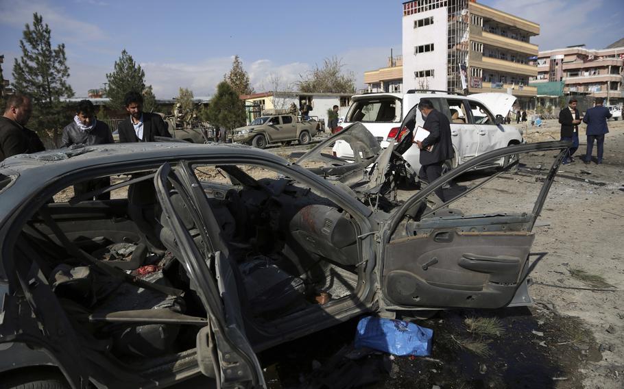 Local security personnel gather at the site of car bomb attack in Kabul, Afghanistan, Wednesday, Nov. 13, 2019. A car bomb detonated in the Afghan capital during Wednesday's morning commute, killing seven people and wounding at least 10, officials said. 