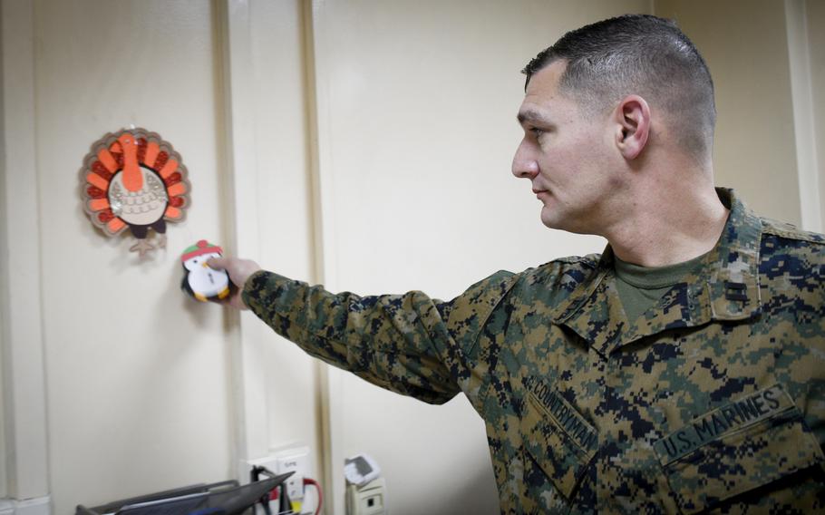 Capt. Christopher Countryman, a Marine deployed to the central NATO and international coalition base in Kabul, Afghanistan, puts up a decorative penguin on the walls of his office to celebrate Christmas of 2019.  