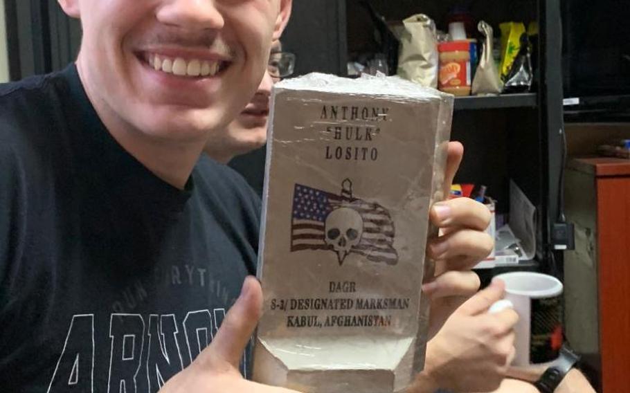 Spc. Anthony Losito, 20, opens his present, a gift from his teammates while deployed to the central NATO and international coalition base in Kabul, Afghanistan, on Christmas of 2019. 
