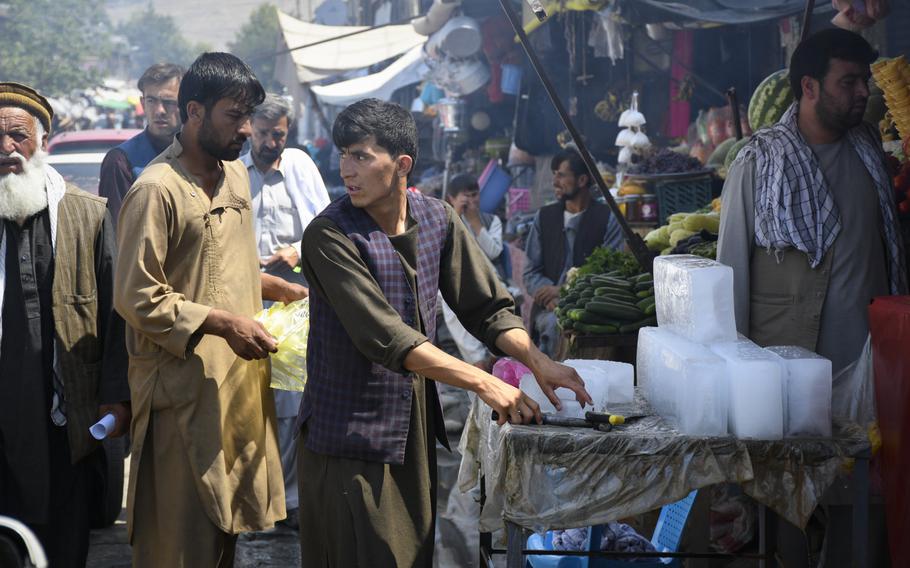 A boy in the town of Baharak cuts ice for customers at the market on July 14, 2019. Baharak, a district center in Afghanistan's remote Badakhshan province, was once safe but is now under Taliban threat.