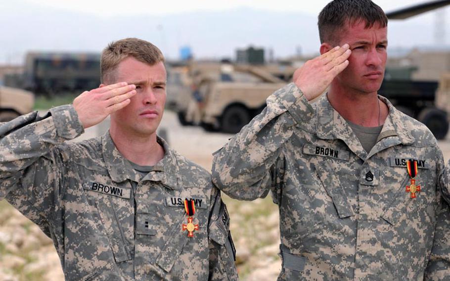Chief Warrant Officer 2 Jason Brown, left, and Staff Sgt. Travis Brown, of 5th Battalion, 158th Aviation Regiment, based Katterbach, Germany, salute during the national anthem on May 2 after receiving Germany&#39;s Gold Cross.