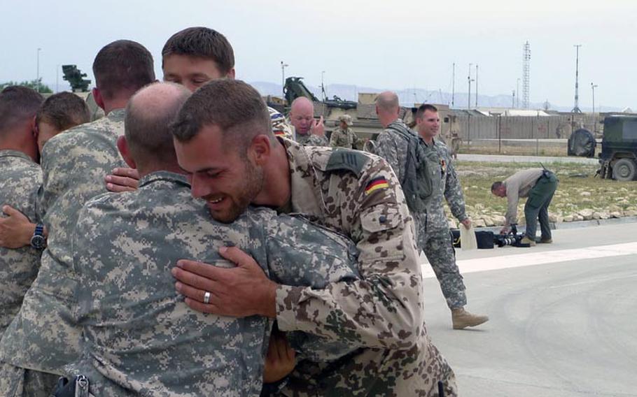 A German soldier (right) hugs U.S. Army Sgt. William Ebel of 5th Battalion, 158th Aviation Regiment on May 12 after Ebel received Germany&#39;s Gold Cross  in Kunduz, Afghanistan.