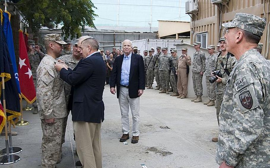 Sens. John McCain,  Lindsey Graham and Joe Lieberman help promote U.S. Marine Staff St. Antonio Aburto during a ceremony at Camp Eggers in Kabul  on Sunday.