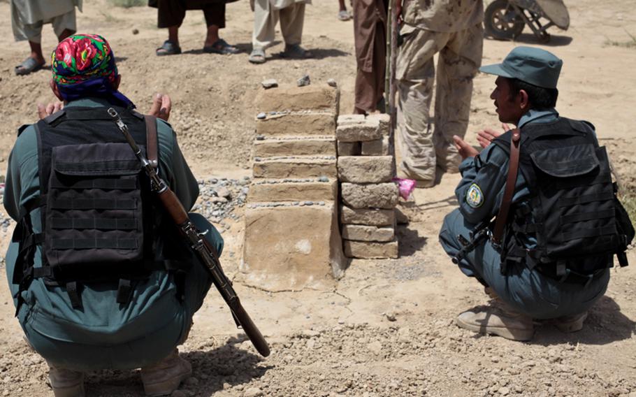 Afghan policemen stop for a moment of prayer at the grave of Nasr Mohammed, a local anti-Taliban leader popular with U.S. forces. Mohammed stood up a group of about two dozen men to protect the village of Zormashor, in Dand district, Kandahar province, Afghanistan from the Taliban, but was shot dead by unidentified gunmen in Kandahar city two months later. June 27, 2010.