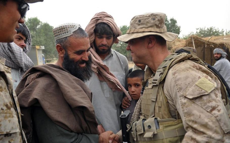Gunnery Sgt. Brandon Dickinson, known to local residents as Gunny D, greets a villager whose family was killed during the initial offensive into Marjah but who has nevertheless befriended the Americans.