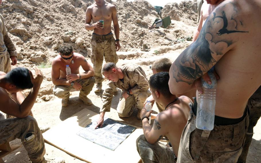 Cpl. Chad Wilson debriefs his squad following a firefight with insurgents in Marjah District on June 20. Wilson said the insurgents fired from buildings believed to have IEDs planted in front of them.