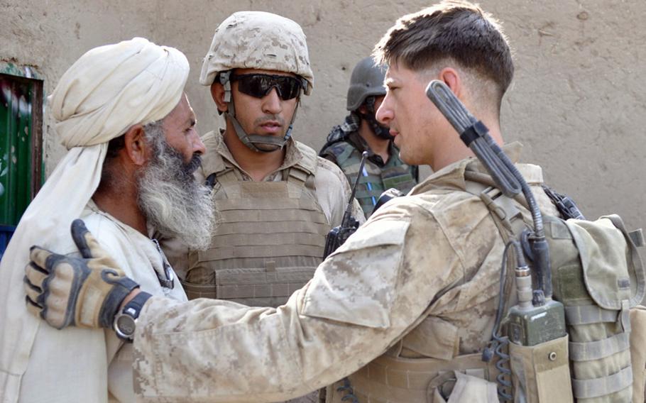 Marine 1st Lt. Dave Emison, 25, who leads the 2nd Platoon, talks with a homeowner during the search of his compound in Marjah District on June 25.